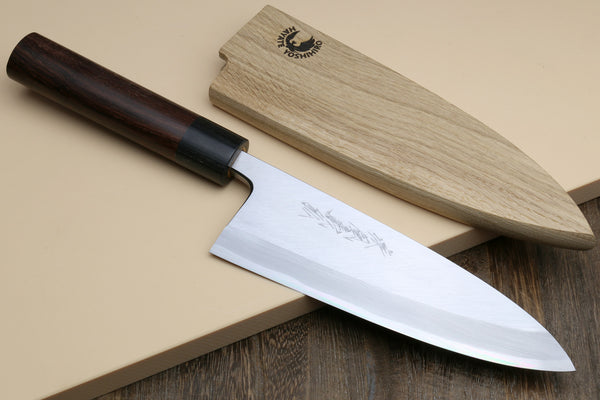 Deba fish fillet knife with white blade and dark rosewood handle, angled on surface