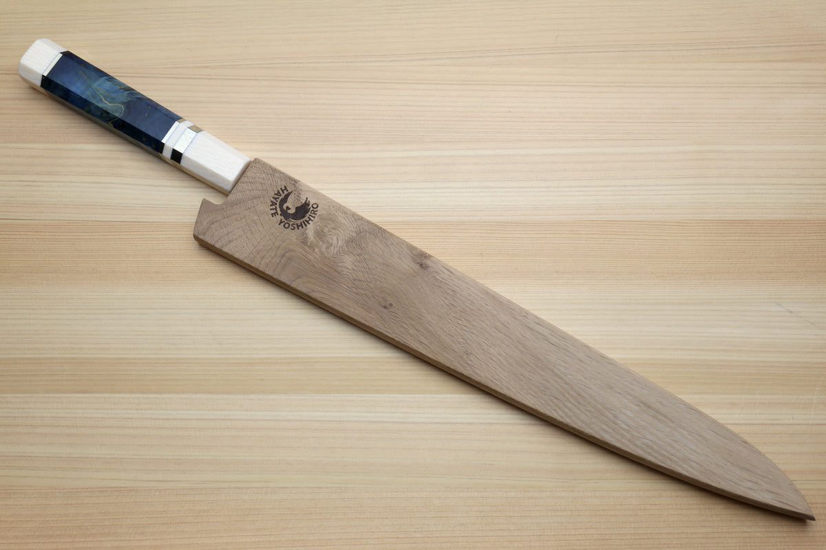 A Japanese-style kitchen knife with a wooden handle and a dark blue marbled handle inlay, resting diagonally on a light wood grain surface. The handle features a black dragon logo.