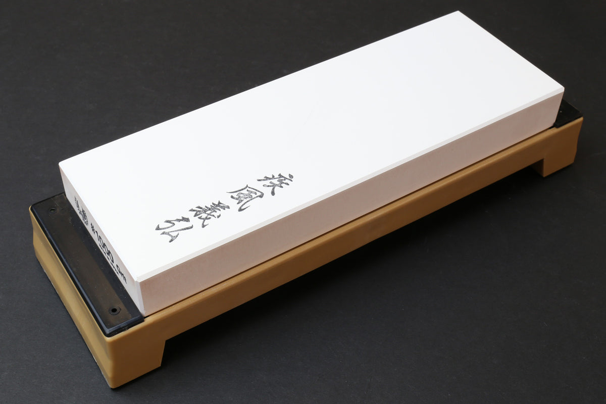 Sharpening whetstone with white rectangular stone block on beige base