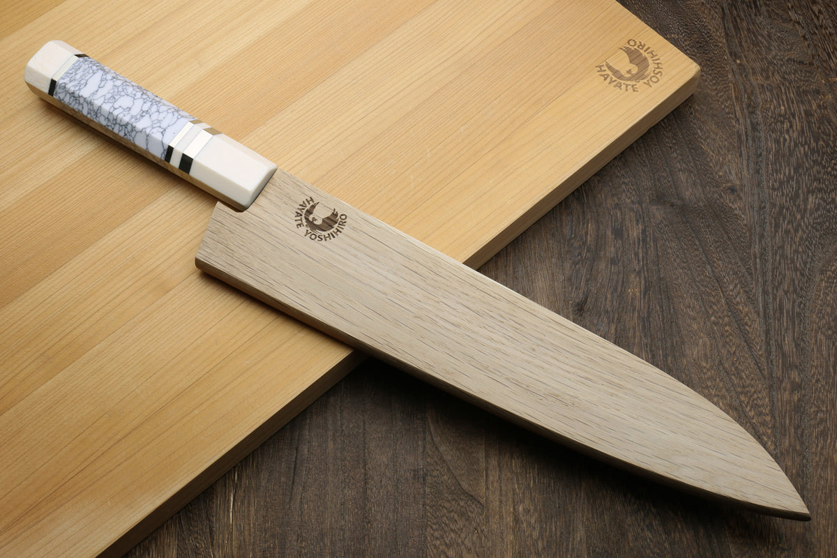 Gyuto chef knife with hammered stainless blade and white handle, ivory bolster