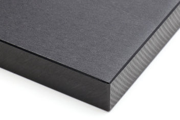 Close-up of black cutting board edge with textured side and corner