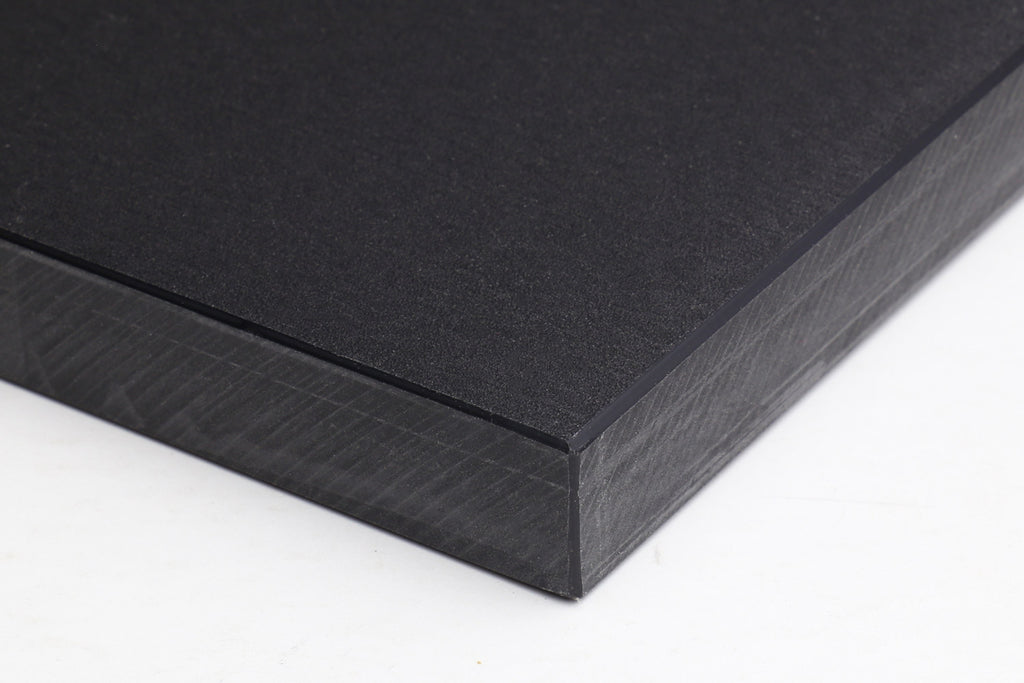 Close-up of a black cutting board edge, fine matte texture and straight sides