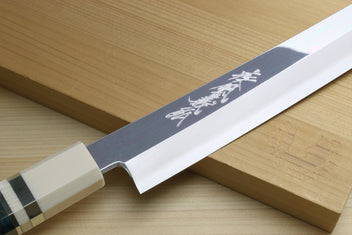 Polished stainless yanagi knife blade showing engraved marks near the bolster