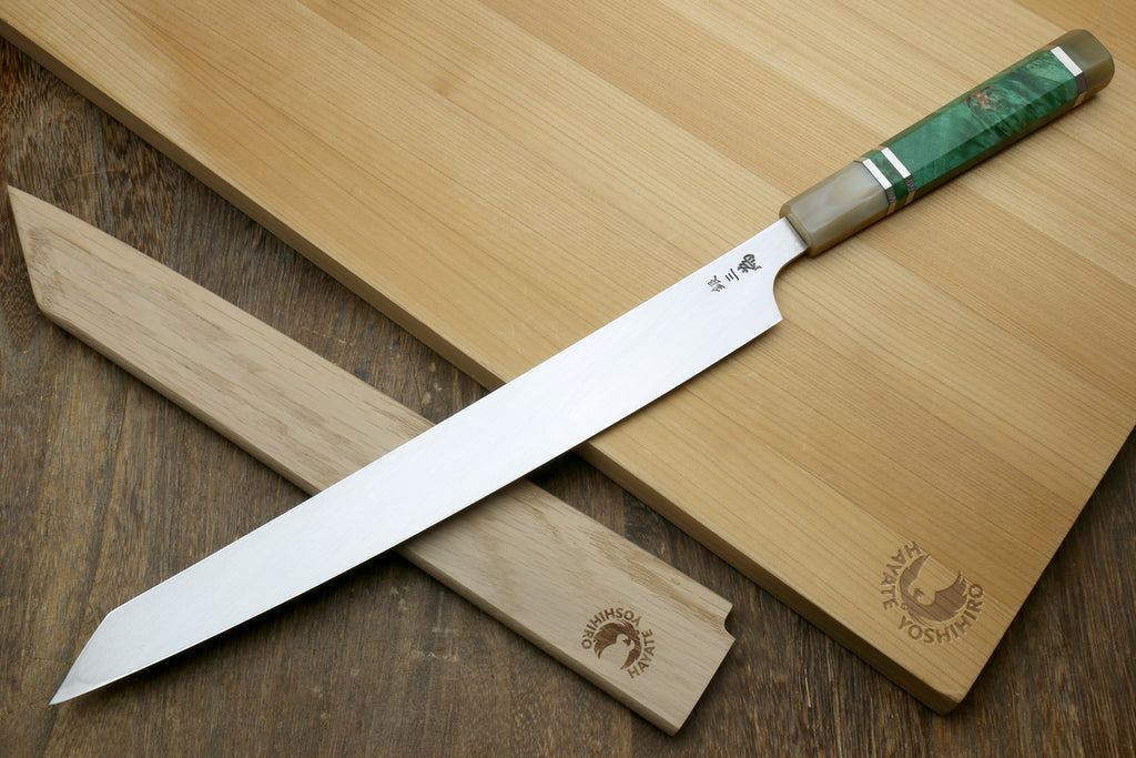 Knife with a green handle on a wooden cutting board