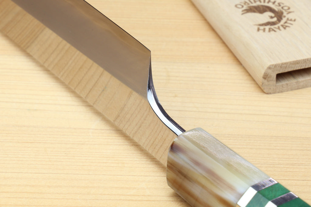 Knife heel reflecting the surface of the cutting board it is on