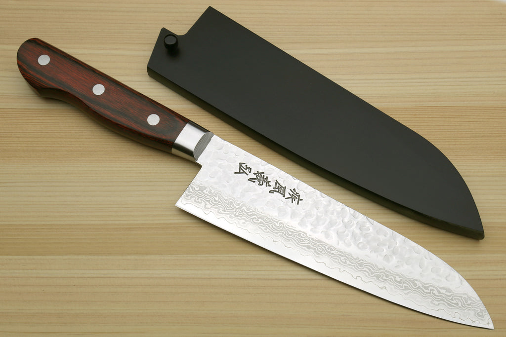 Santoku knife with a wooden handle and black sheath on a wooden surface