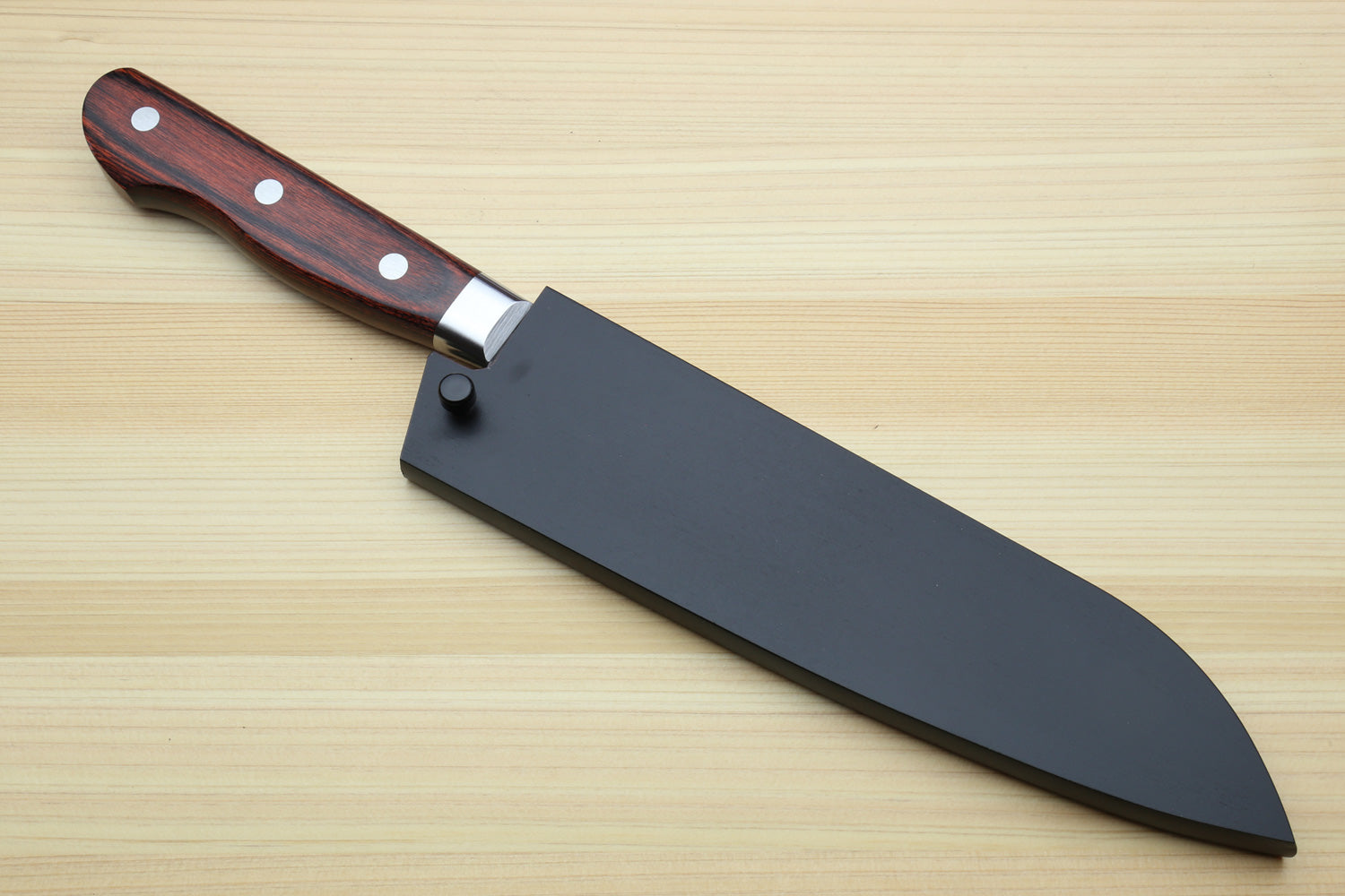 Sheathed chef's knife with wooden handle on a wooden surface