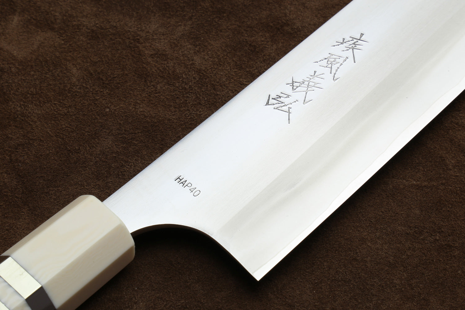 Knife with a white handle and blade featuring engraved text on a brown background