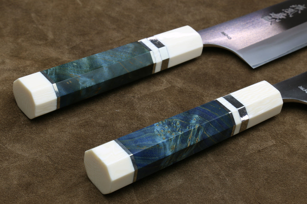 Two knives with decorative handles on a brown surface