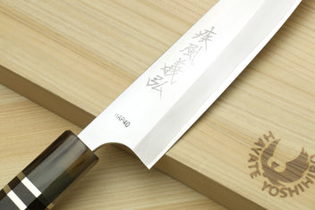 Petty chef knife blade close-up with etched marks and dark triple-ring handle