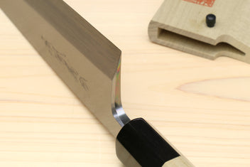 Sushi and sashimi knife close-up, silver blade bevel with black bolster and light wood handle