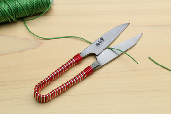 Japanese sewing snip scissors with green thread and red string-wrapped handle