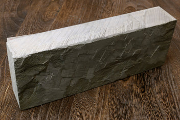 Natural whetstone finishing stone, dark grey rectangular block with striated texture