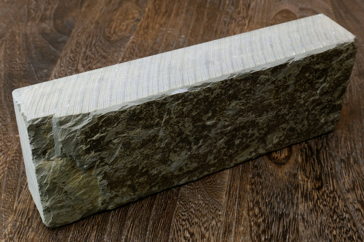 Natural sharpening whetstone block with dark green surface and pale sides