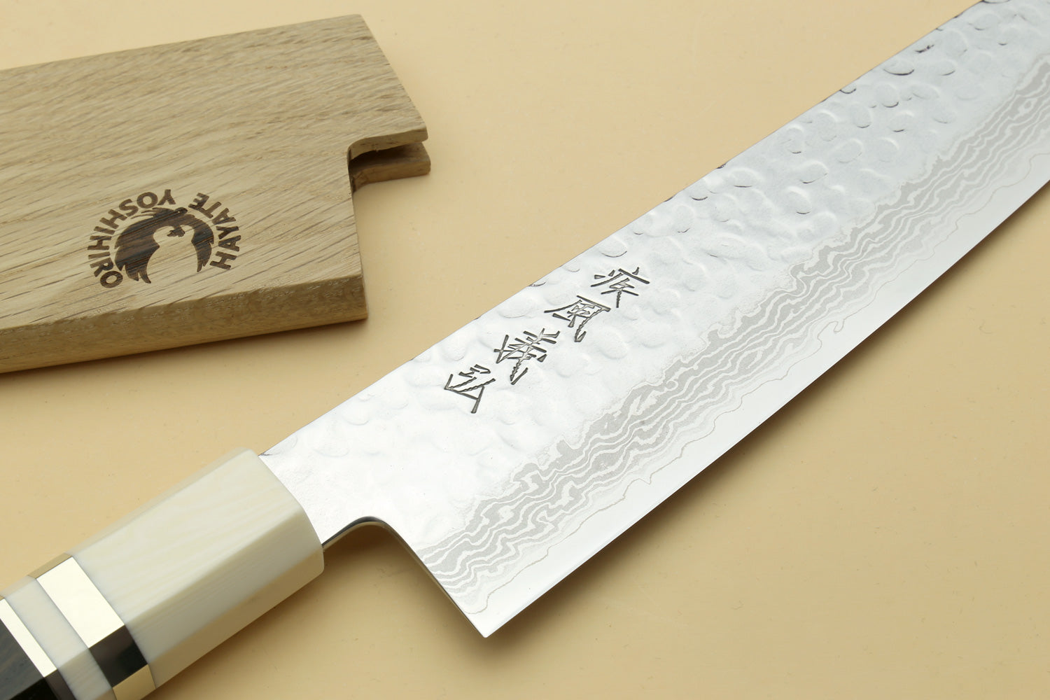Close-up of Damascus gyuto blade with ivory-look octagonal handle