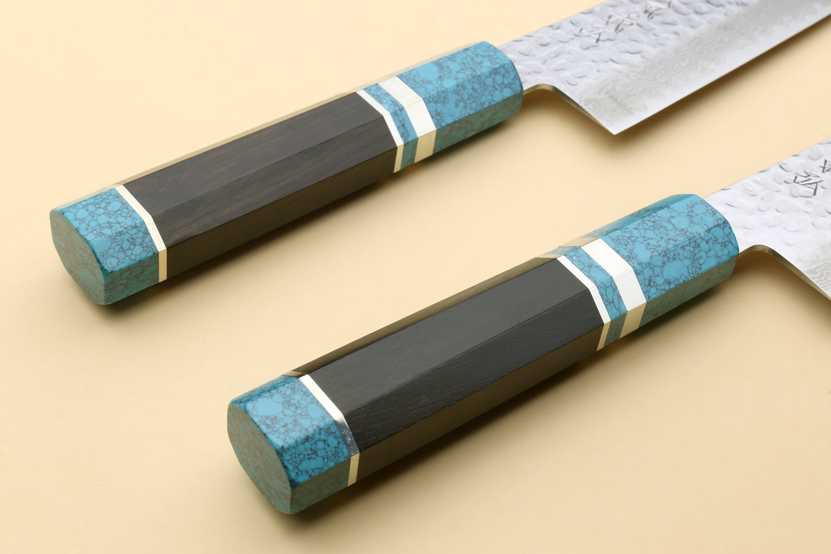 Two chef's gyuto knives with turquoise blue octagonal handles and hammered Damascus blades