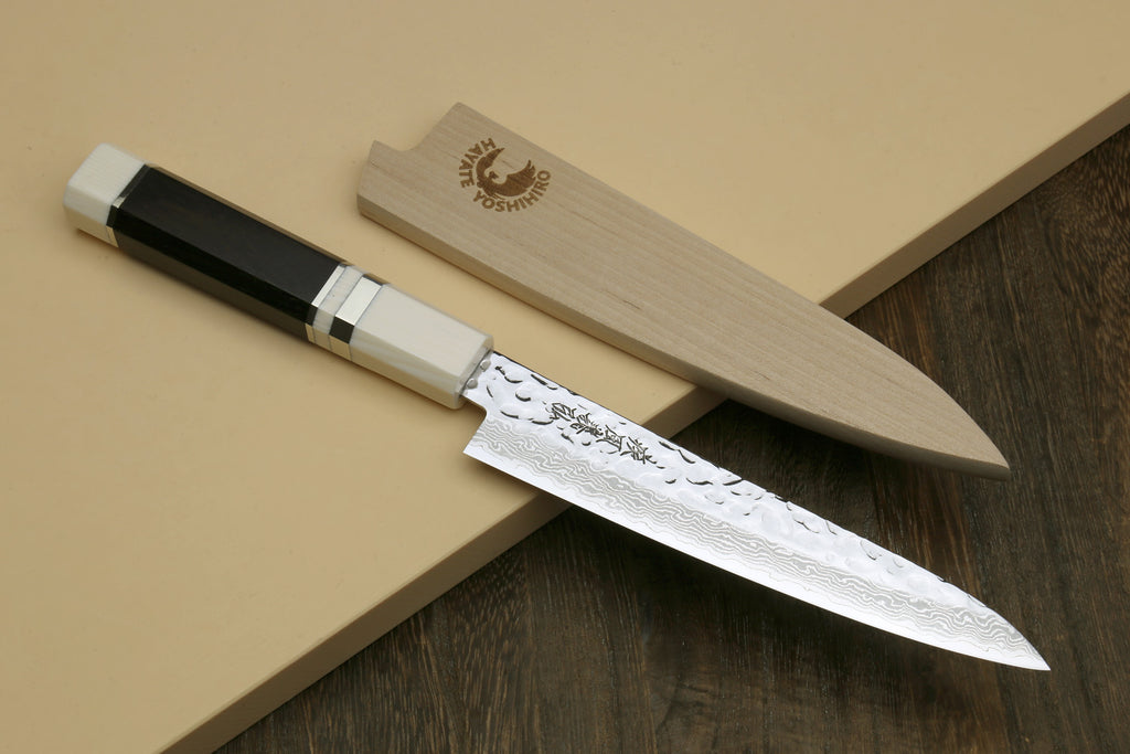 Two Damascus knives on wood display blocks with ivory-look octagonal handles