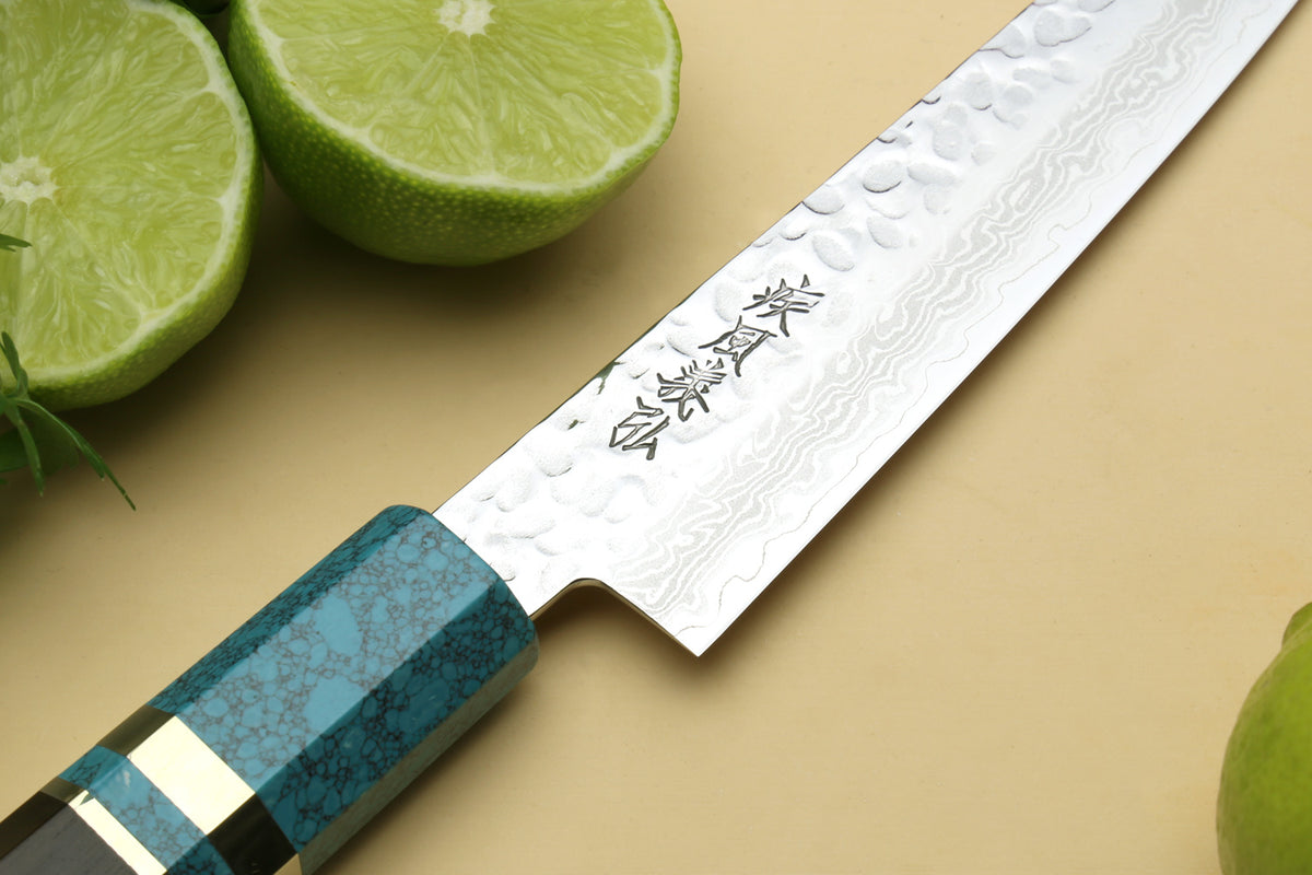Damascus blade close-up with etched marks and turquoise blue handle.
