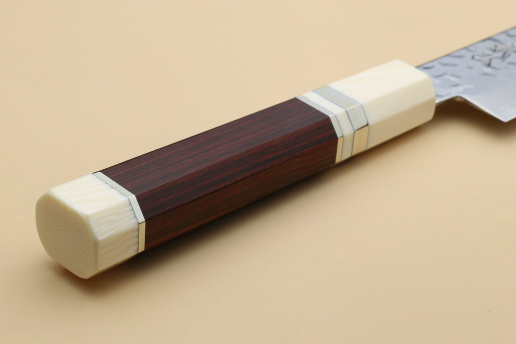 A close-up of a rosewood Handle with Alternative Ivory Bolster