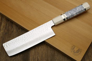 Nakiri vegetable knife with white howlite handle and Damascus blade on wooden board