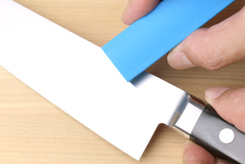 Rust eraser polishing a knife blade with a blue block