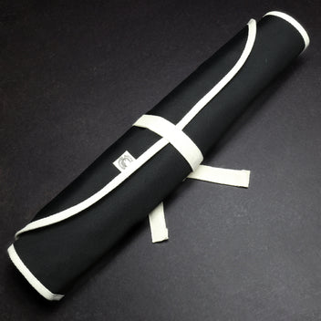Rolled black cotton knife pouch with white wrap ties and small logo patch
