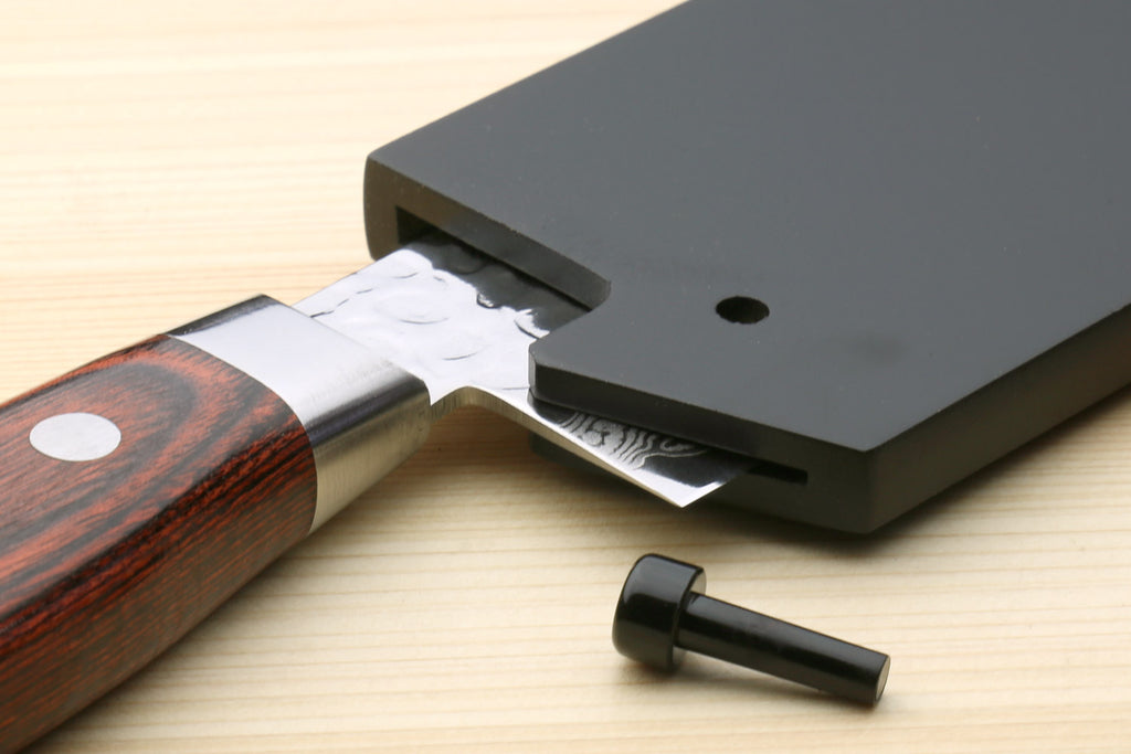Close-up of a Knife with a lacquered wooden Sheath on a light wood surface