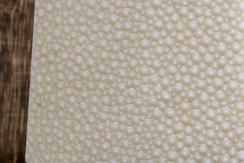White sharkskin grating surface with small circular bumps