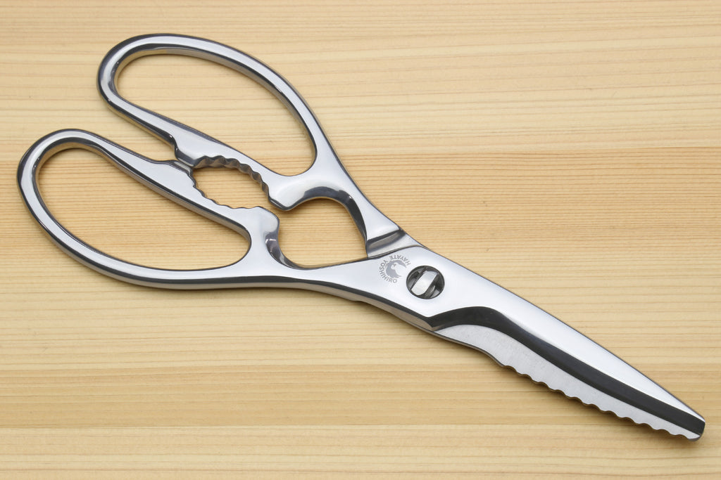 Stainless steel kitchen shears with straight and scalloped grip blades and oval loop handles.