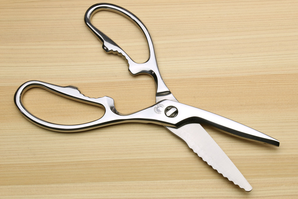 Stainless steel kitchen shears blade tips, straight edge and scalloped grip edge, with oval loop handles.