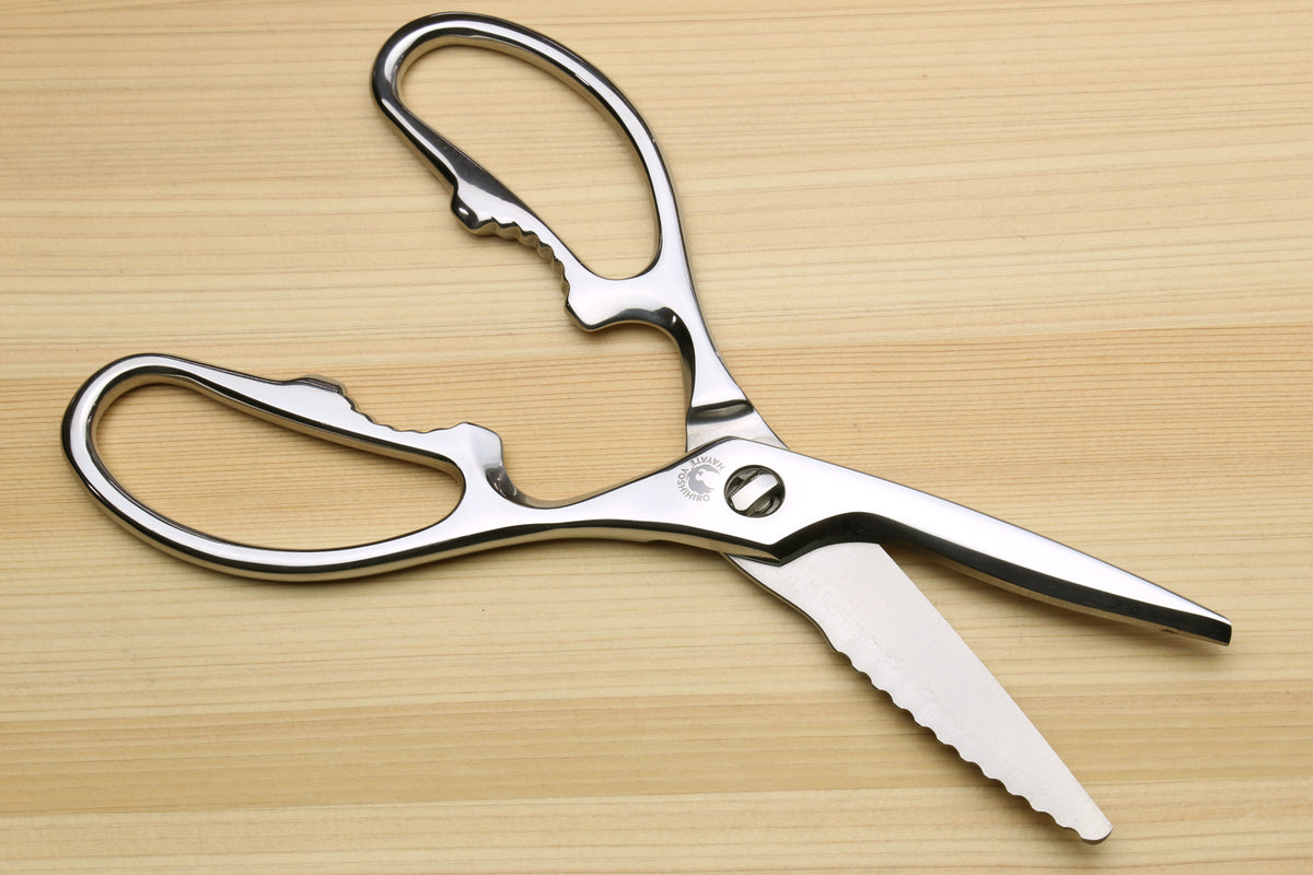 Stainless steel kitchen shears blade tips, straight edge and scalloped grip edge, with oval loop handles.