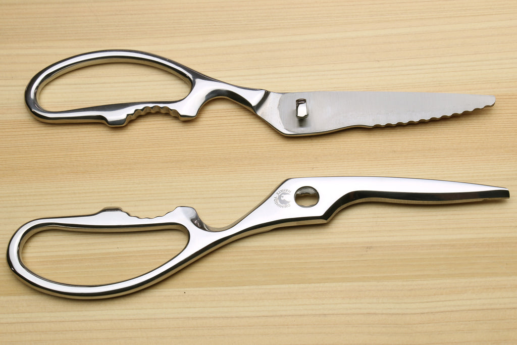 Stainless steel kitchen shears with oval loop handles, side view.