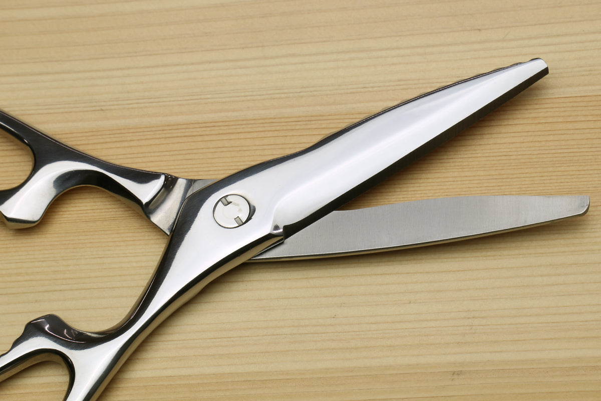 Stainless steel kitchen shears with straight and scalloped grip blades, riveted pivot, and loop handles.