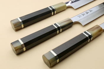 Yanagi kiritsuke knife with mirror-polished blade and dark triple-ring ebony handle