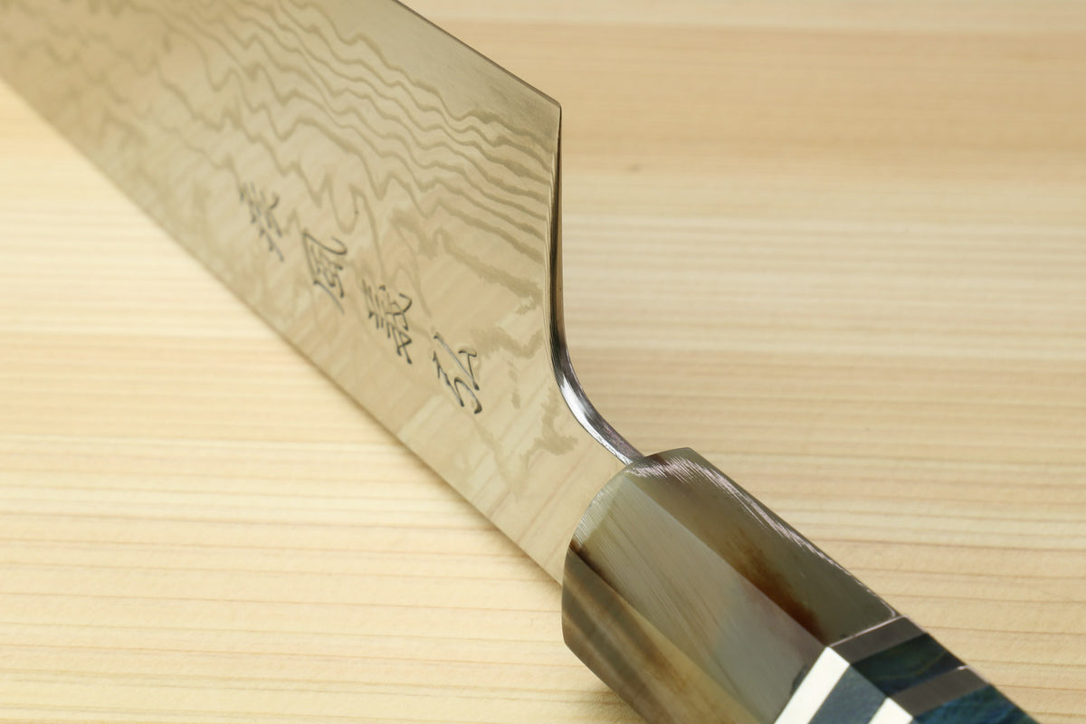 Kiritsuke chefs knife partial view with damascus blade and blue handle