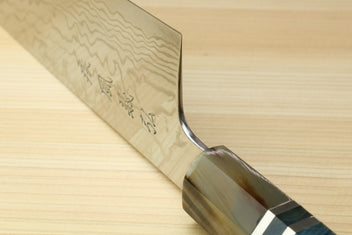 Kiritsuke chefs knife partial view with damascus blade and blue handle