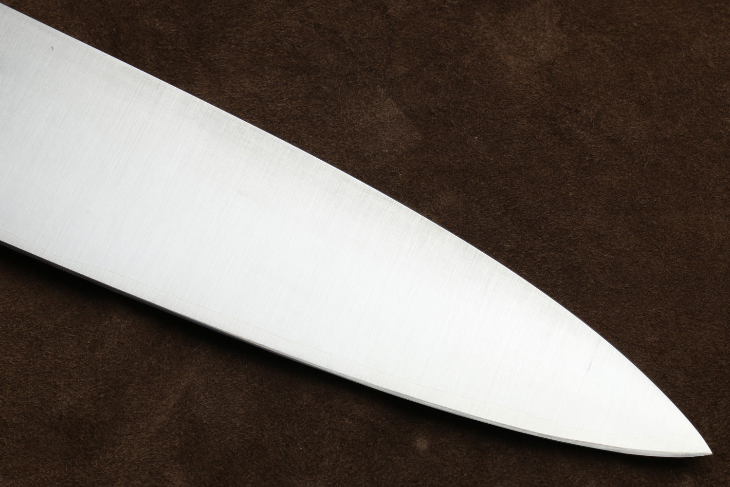 Close-up of a knife blade on a brown background