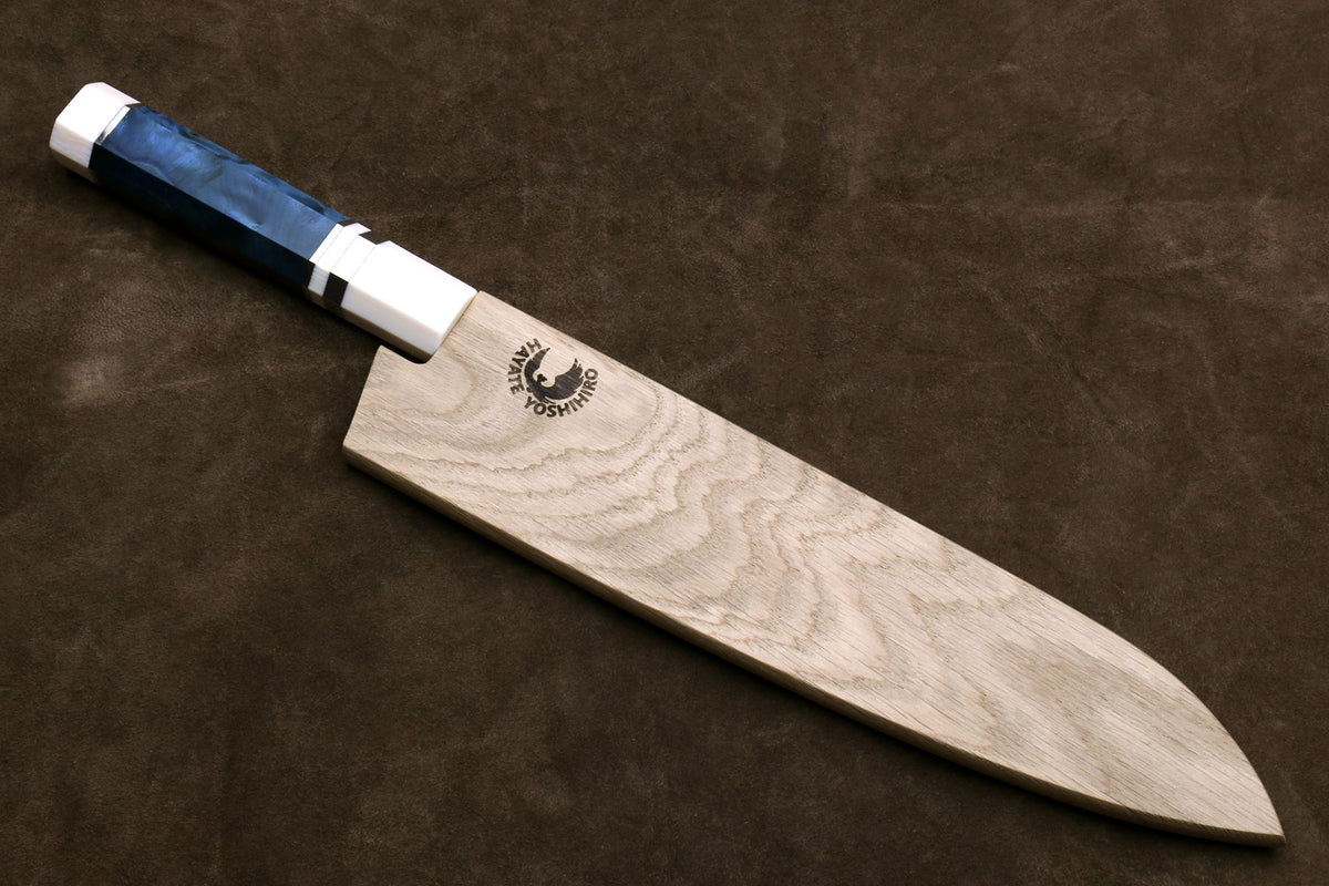 Gyuto chef knife with stainless blade, ivory bolster, octagonal blue handle on wooden block