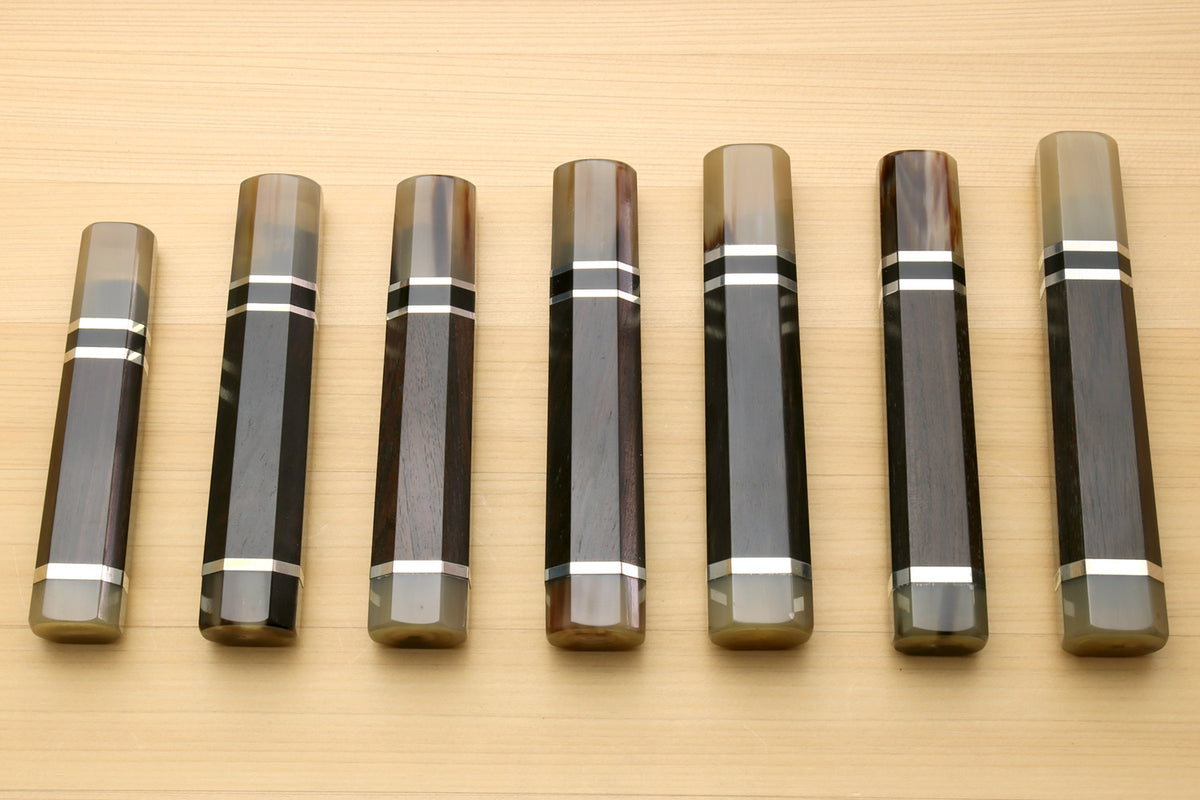 Chef knife handles lineup with horn bolster ends and black-and-white triple ring stripes, for Kiritsuke knives