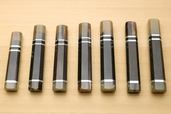 Chef knife handles lineup with horn bolster ends and black-and-white triple ring stripes, for Kiritsuke knives