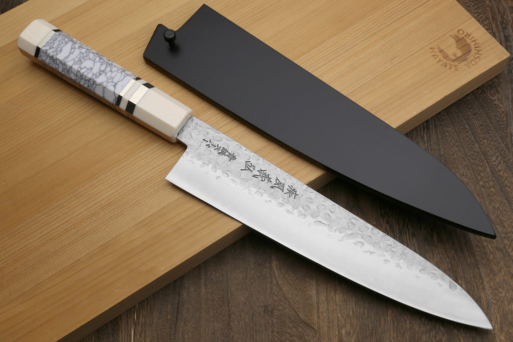 Chef's knife with a sheath on a wooden surface