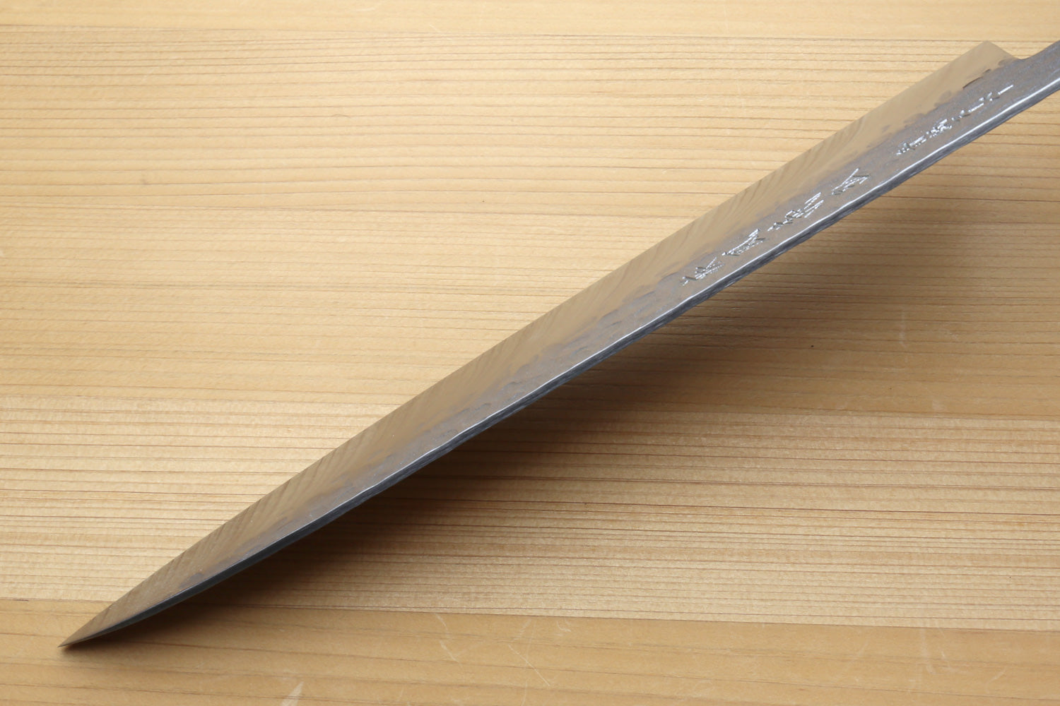 long knife blade on a cypress wood cutting board