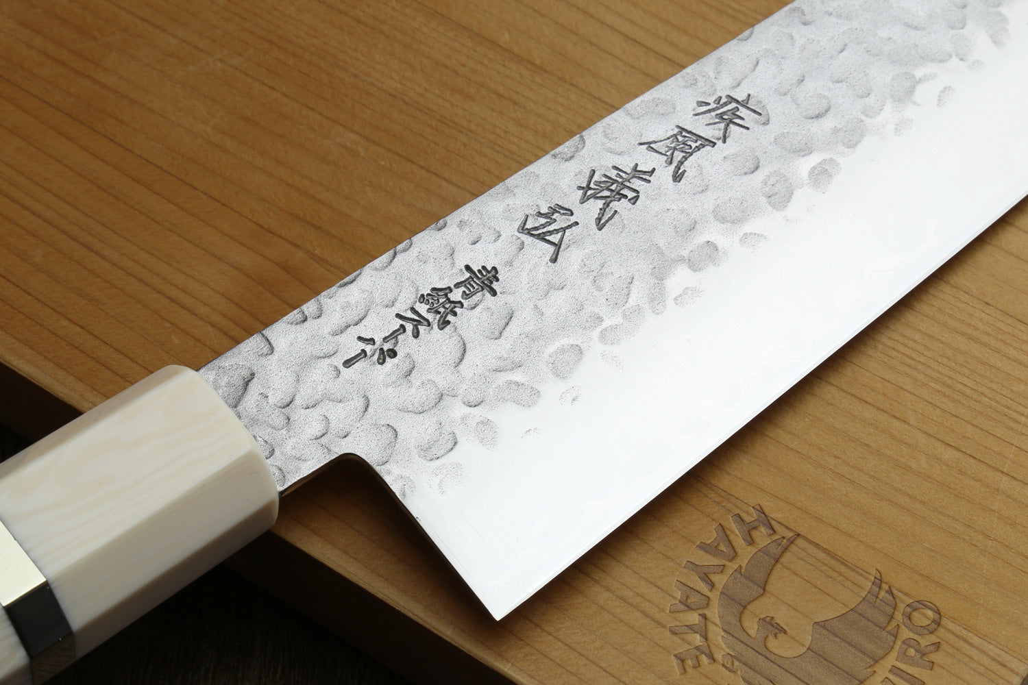 Close-up texts and on a textured blade on a wooden surface
