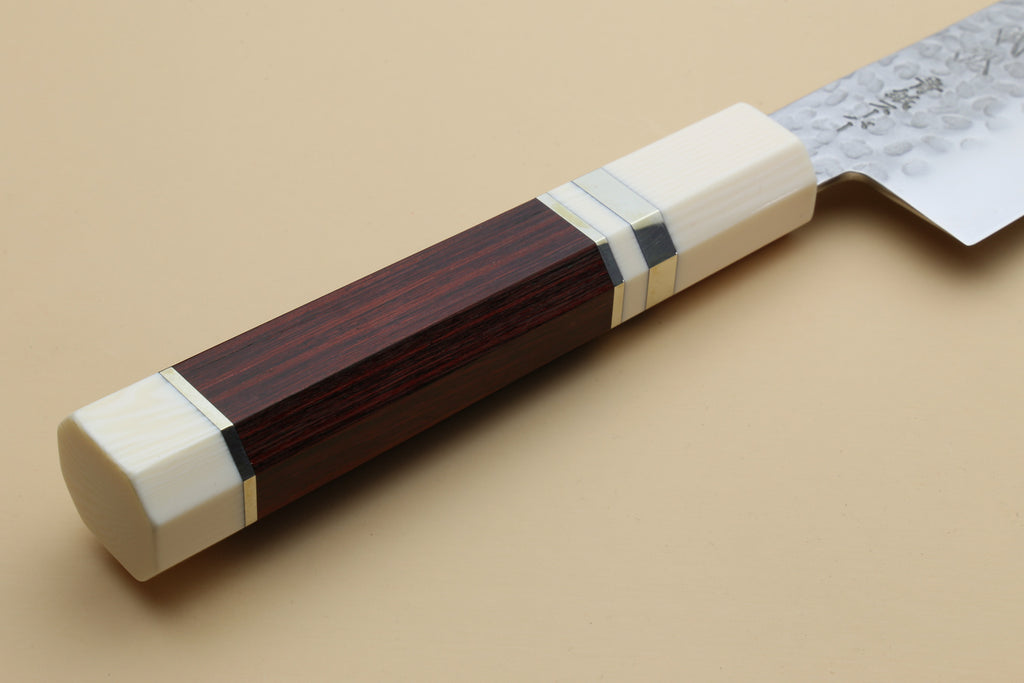 Chef's gyuto knife handle close-up: rosewood scales with white/ivory end and bolster