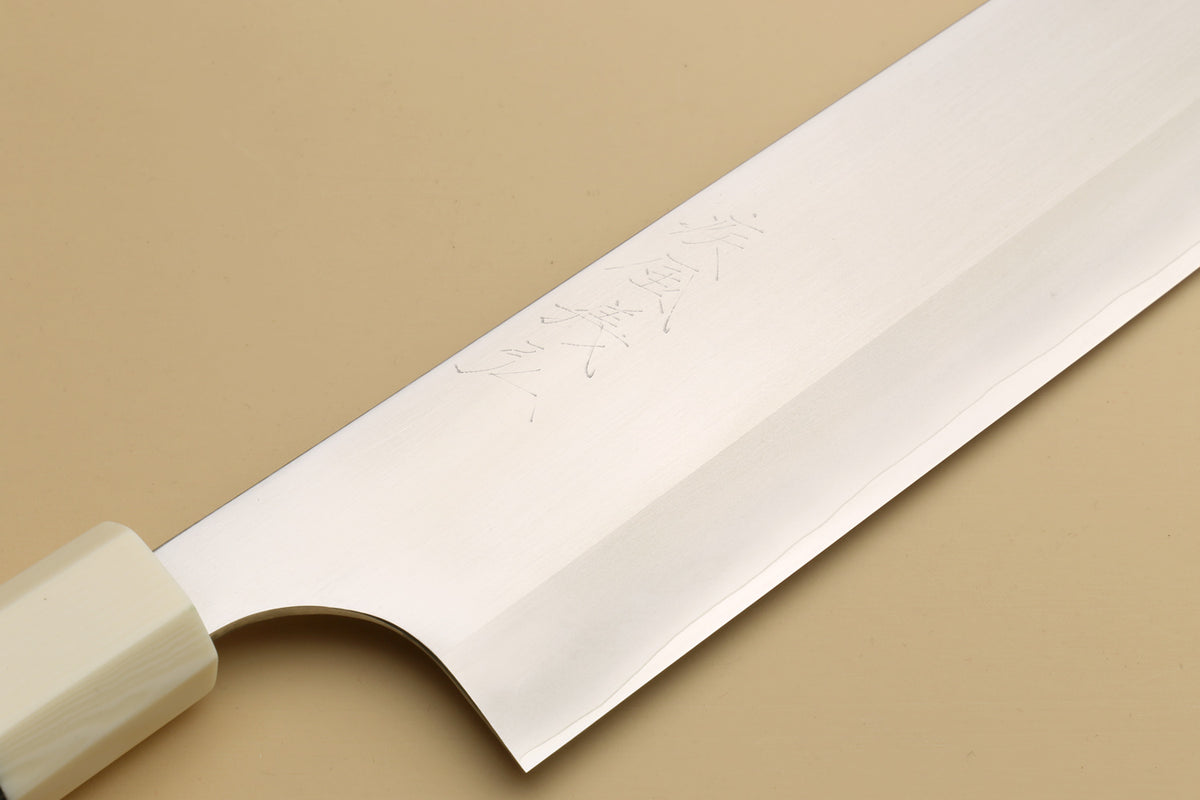 Gyuto knife blade close-up showing etched markings and sharpened edge