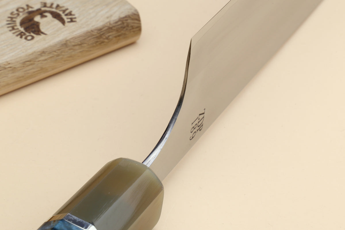 Gyuto chef's knife close-up of blade heel and olive-toned handle bolster