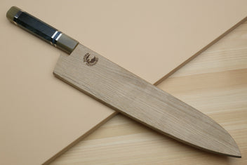 Gyuto chef's knife partly covered by a wooden blade guard