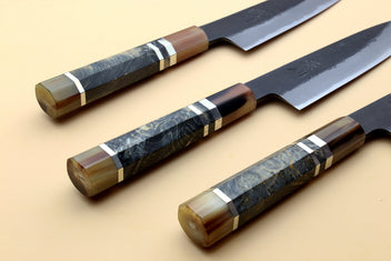 Three petty utility knives with dark blue steel blades and wood handles
