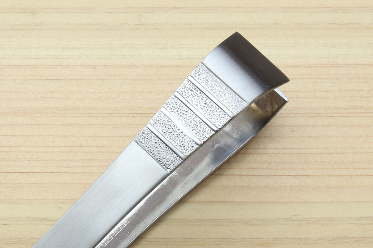 Stainless steel tweezer end with textured grip panel and open jaws
