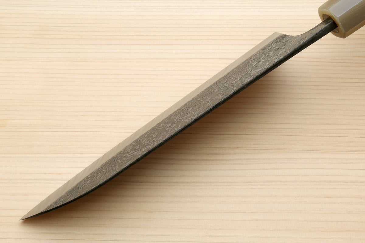 Damascus santoku blade in profile with dark spine and sharpened edge